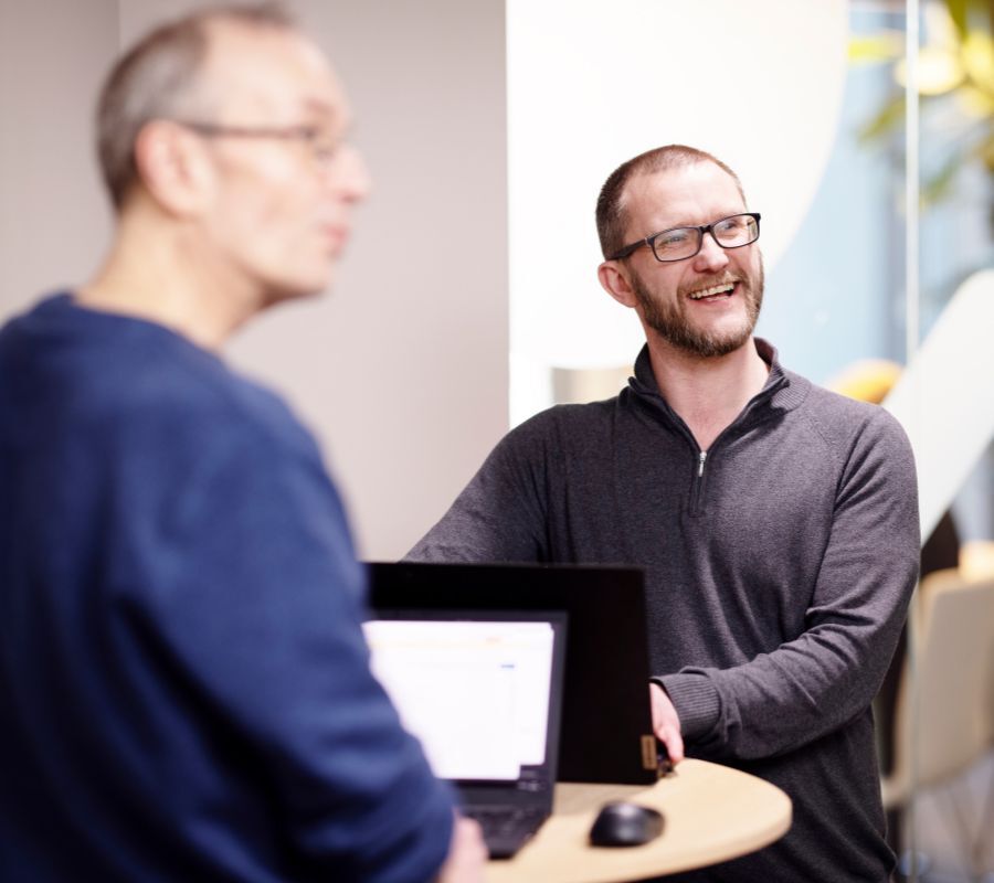 Image of two Cloudworks consultants smiling and laughing in office Image of two Cloudworks consultants smiling and laughing in office