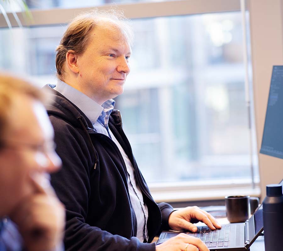 Arne in front of PC with Kristian in the foreground_900x800