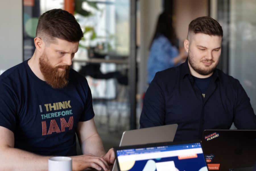 Image of two Cloudworks employees working on laptops in meeting Image of two Cloudworks employees working on laptops in meeting